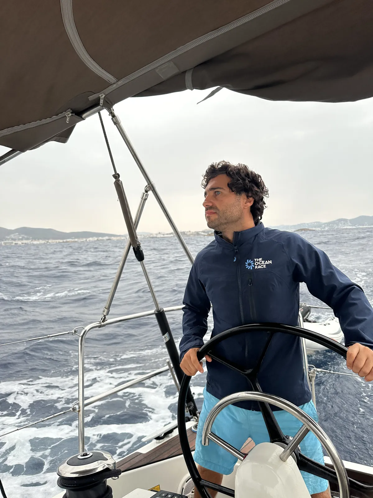 Gabriel, patrón profesional, al timón del velero navegando por Menorca