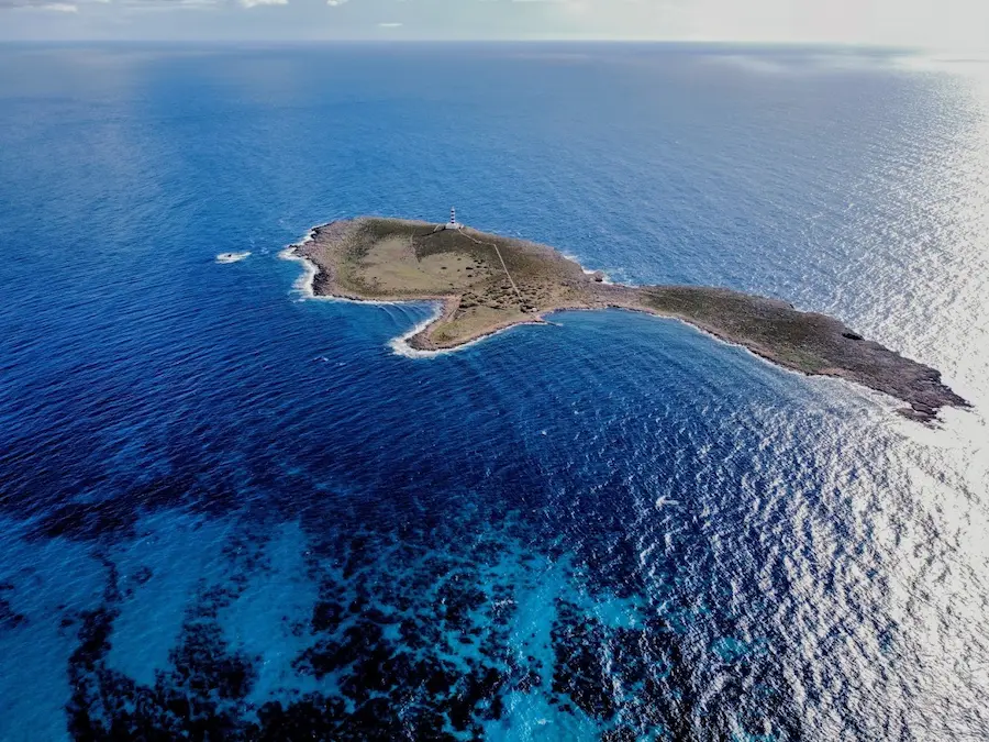 Aerial view of Isla del Aire with its lighthouse, off Punta Prima on Menorca's south coast