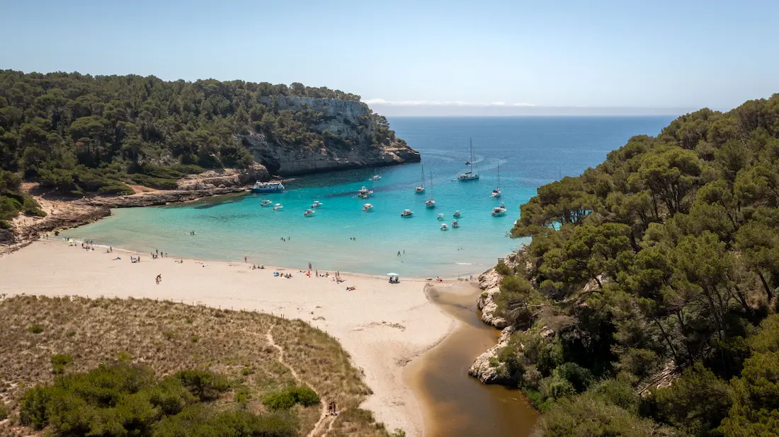 Playa de aguas turquesas en la costa sur de Menorca, ruta sur de una excursión en velero