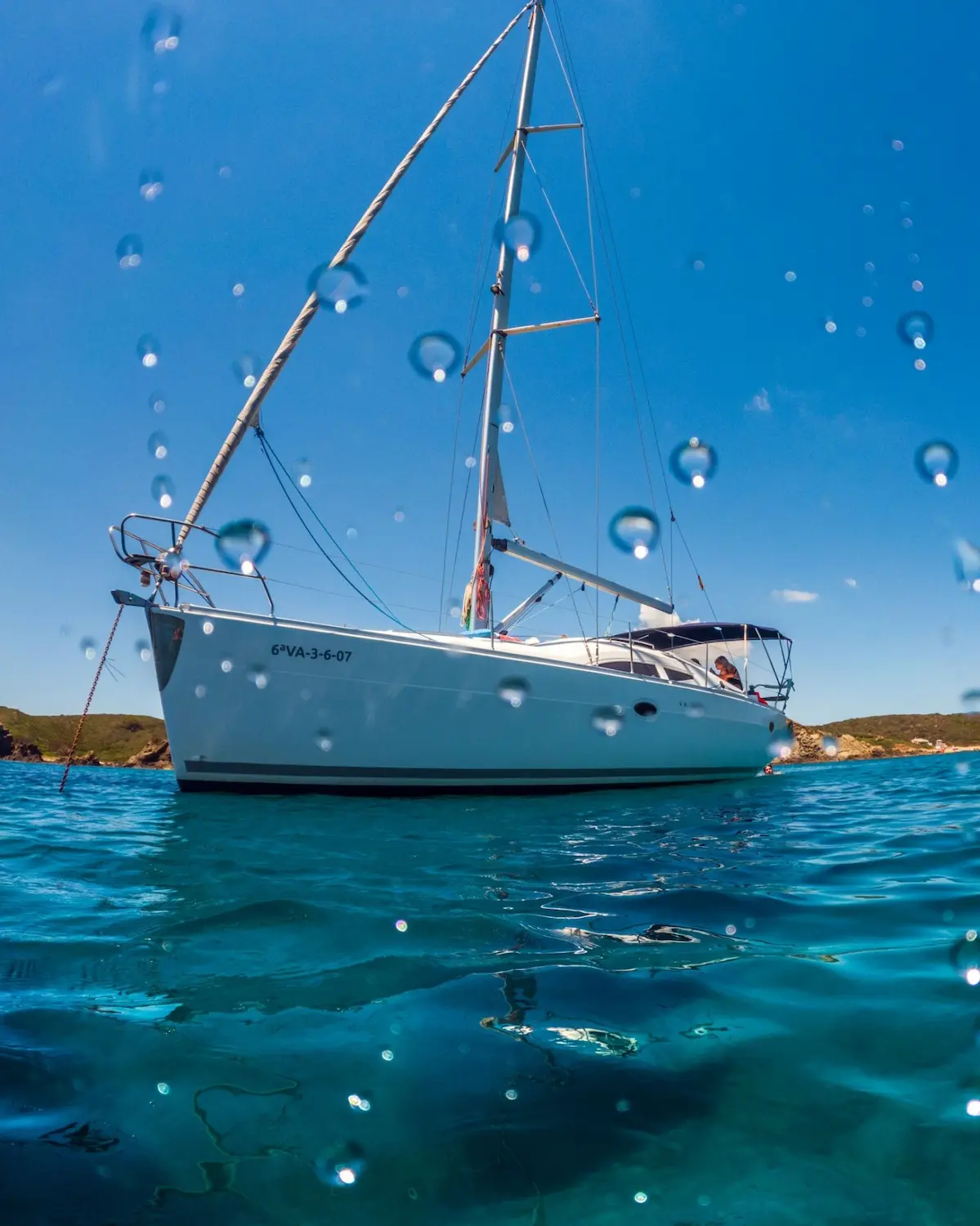 Elan sailboat anchored in turquoise waters during a trip around Menorca