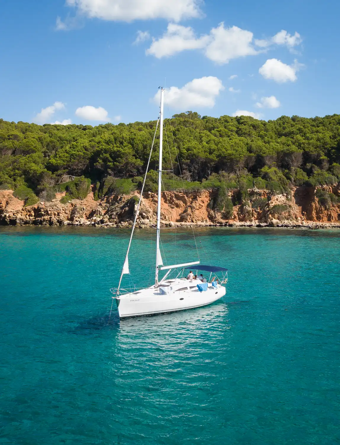 Velero fondeado en una cala virgen de la costa norte de Menorca accesible solo en barco