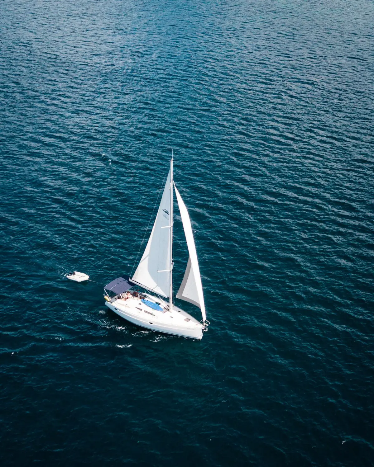 Velero navegando a vela por aguas turquesas de Menorca, ilustrando la mejor época para navegar